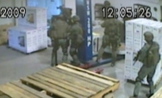 Partial warehouse video of raid; it shows Imam Abdullah and others retreating into trailer after FBI incursion, then raising hands to surrender, and lying down as ordered; Imam stands for a few seconds more, then also lies down; no police dog is seen, view of Imam's killing is blocked by FBI agents, who had no videocameras in the trailer