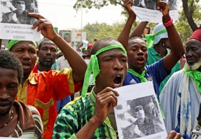 FILE - In this March 19, 2011 file photo, supporters of besieged Libyan leader Moammar Gadhafi cheer as they rally in support of him in the city of Bamako, Mali. While Western powers herald the death of Gadhafi, killed Thursday, Oct. 20, 2011, many Africans are mourning a man who poured billions of dollars of foreign investment into desperately poor countries. Gadhafi backed some of the most brutal rebel leaders and dictators on the continent, but tens of thousands are now gathering at mosques built with his money and are remembering him as an anti-colonial martyr, and as an Arab leader who called himself African. (AP Photo/Harouna Traore, File)