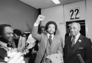 The Rev. Benjamin  Chavis gives a clenched fist salute after arriving at Washington National Airport on Friday, Dec. 14, 1979, after being paroled by North Carolina Gov. Jim Hunt. Chavis, one of the Wilmington 10 defendants, was convicted in connection with the 1972 firebombing of a Wilmington, N.C. grocery. At right is Dr. Charles Cobb, a United Church of Christ official, for whom Chavis will work. (AP Photo/Charles Tasnadi)