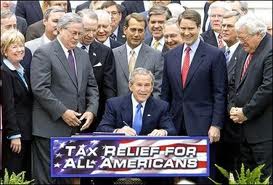 Bush signing his tax cut for the rich legislation.