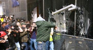 Demonstrator smashes window at RBS branch in London.