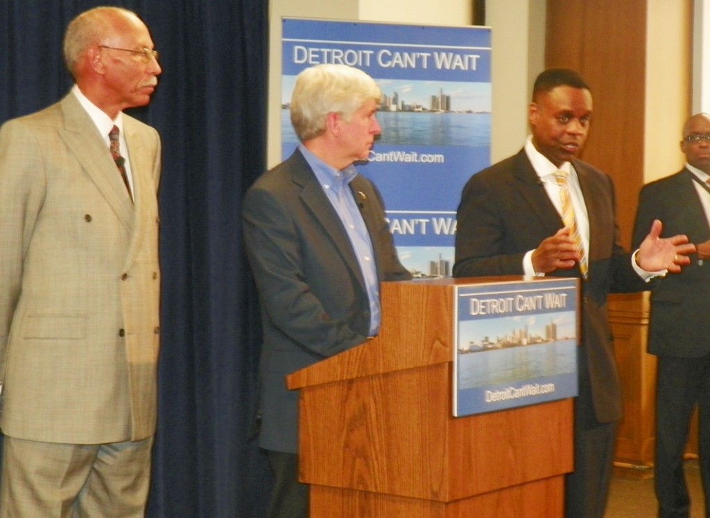 Kevyn Orr (r) addresses media at press conference March 14, 2013. Detroit Mayor Dave Bing and Michigan Gov. Rick Snyder (l to center) listen attentively.
