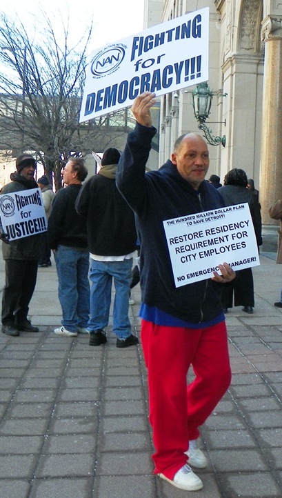 Protester outside Gov. Rick Snyder's press conference announcing Detroit takeover by EM March 14, 2013.