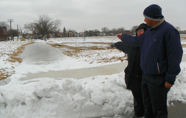 Sheila Crowell and neigbhor point out iced over walkway on Munger grounds that they fear will melt in the spring and contaminate new soil laid over old.