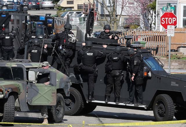 Military-style manhunt for bombing suspect in Boston suburbs April 19, 2013. News media are championing paramilitary  forces involved, saying this incident should convince U.S. public to cede their civil liberties in some circumstances. 