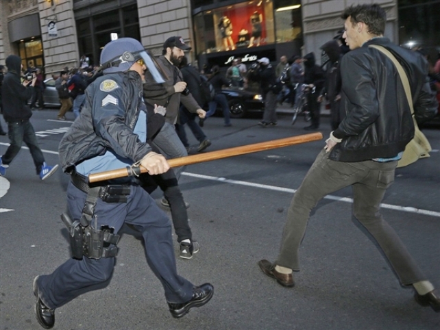 A Seattle Police officer with a baton tries to fend off protesters during a May Day anti-capitalism protest that ended with demonstrators clashing with police on Wednesday. Ted S. Warren / AP
