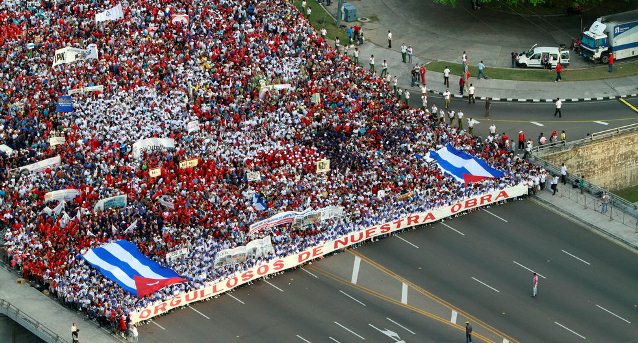 People hold a banner that reads in Spanish "Proud of our work" at the front of the May Day march to Revolution Square in Havana, Cuba, Wednesday, May 1, 2013. AP / Ismael Francisco 