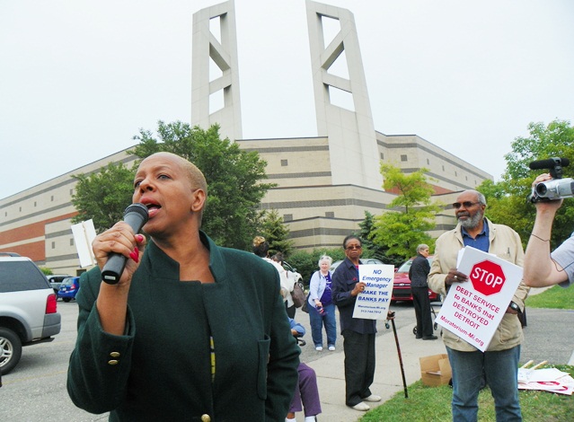 Cynthis Johnson cries out, Detroit is under attack! outside towers of Greater Grace Temple during June 6 protest against EM Orr and banks.