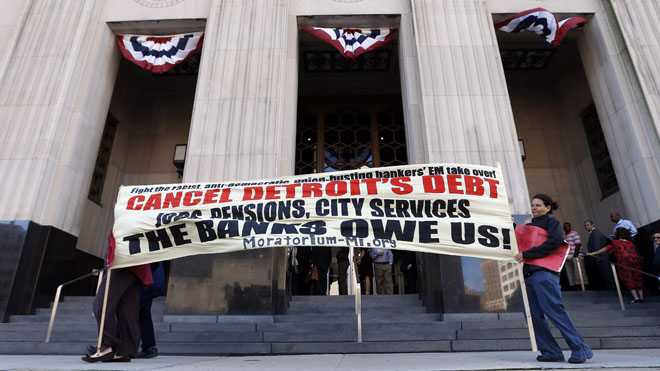 Protesters carry a sign outside the Levin Federal Courthouse in Detroit, Wednesday, July 24, 2013. .(AP Photo/Paul Sancya)