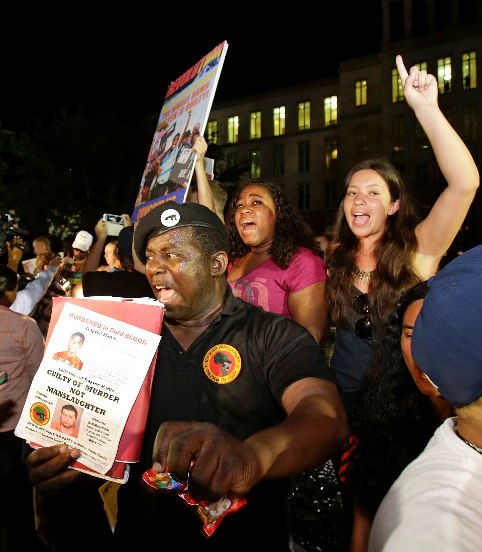 James Evan Muhammad, front left, of the New Black Panther Party, shouts slogans after the verdict of not guilty was handed down in the trial of George Zimmerman at the Seminole County Courthouse, Saturday, July 13, 2013, in Sanford, Fla. Neighborhood watch captain George Zimmerman was cleared of all charges Saturday in the shooting of Trayvon Martin, the unarmed black teenager whose killing unleashed furious debate across the U.S. over racial profiling, self-defense and equal justice. (AP Photo/John Raoux)