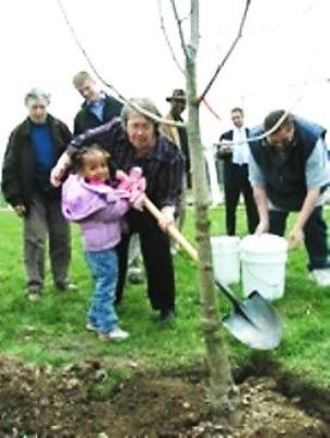 Sheila Crowell helps community members plant trees at what was formerly Dingeman Playfield in a mixed-race neighborhood on Detroit's near west side. Since then, adjacent Chadsey High School, a renowned mutti-ethnic institution, has been closed and the playfield taken over by the city. Poverty and crime increase in Crowell's neighborhood.