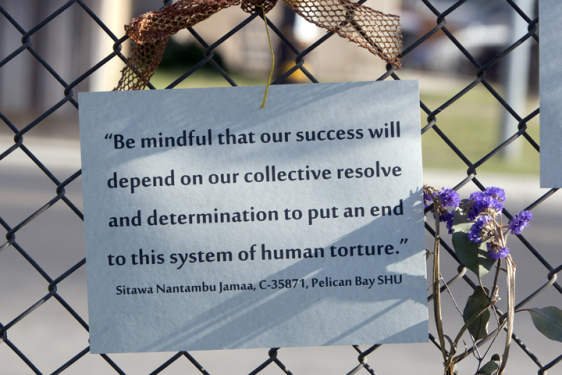 Hunger striker supporters displayed photos and quotations from several of the movement leaders, including Sitawa, at the July 13 rally outside Corcoran State Prison. – Photo: Malaika Kambon