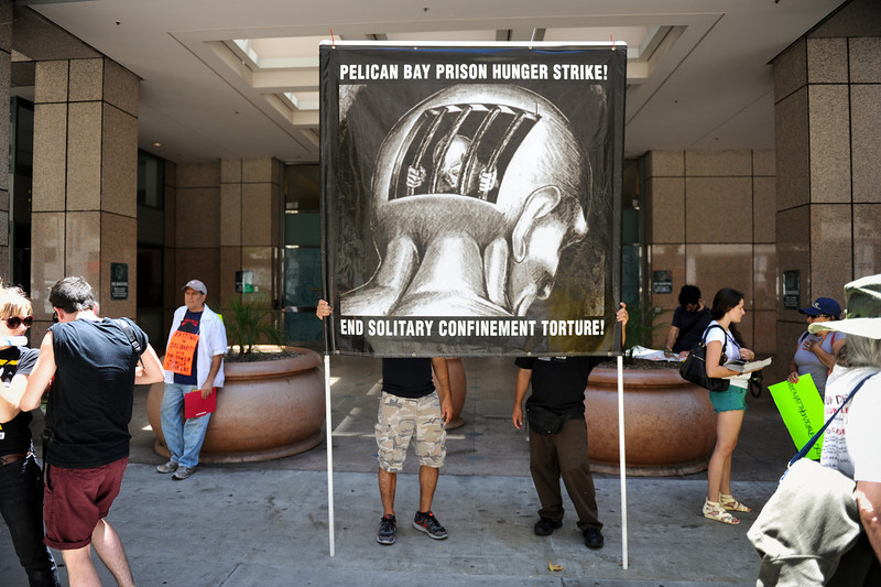 A pair holds a solitary confinement protest sign outside the Ronald Reagan State Building in downtown L.A. Monday, July 8, 2013, during a protest against solitary confinement in California prisons. (Michael Owen Baker/L.A. Daily News)