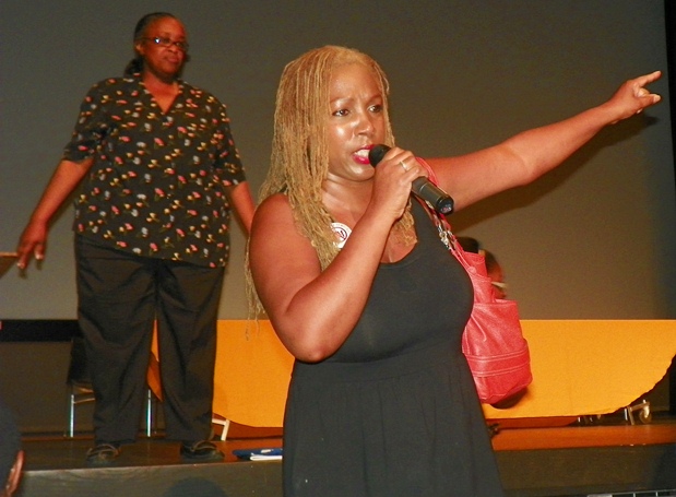 Parent Christal Bonner addresses audience as former speaker, Karen Valentine, listens from stage.