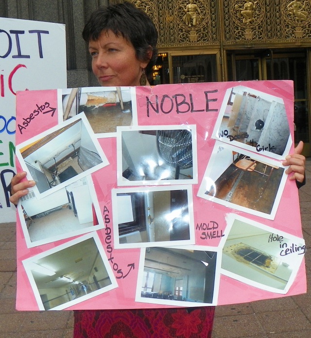 Photos of conditions at Noble are displayed during protest.