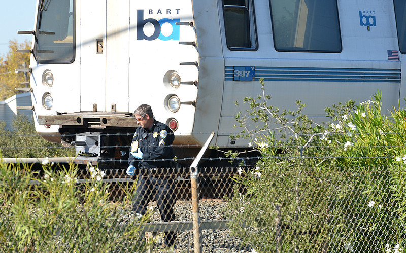 A BART police officer looks along the outside of a BART car that struck and killed two people along Jones Road in Walnut Creek, Calif., on Saturday, Oct. 19, 2013. (Dan Rosenstrauch/Bay Area News Group)