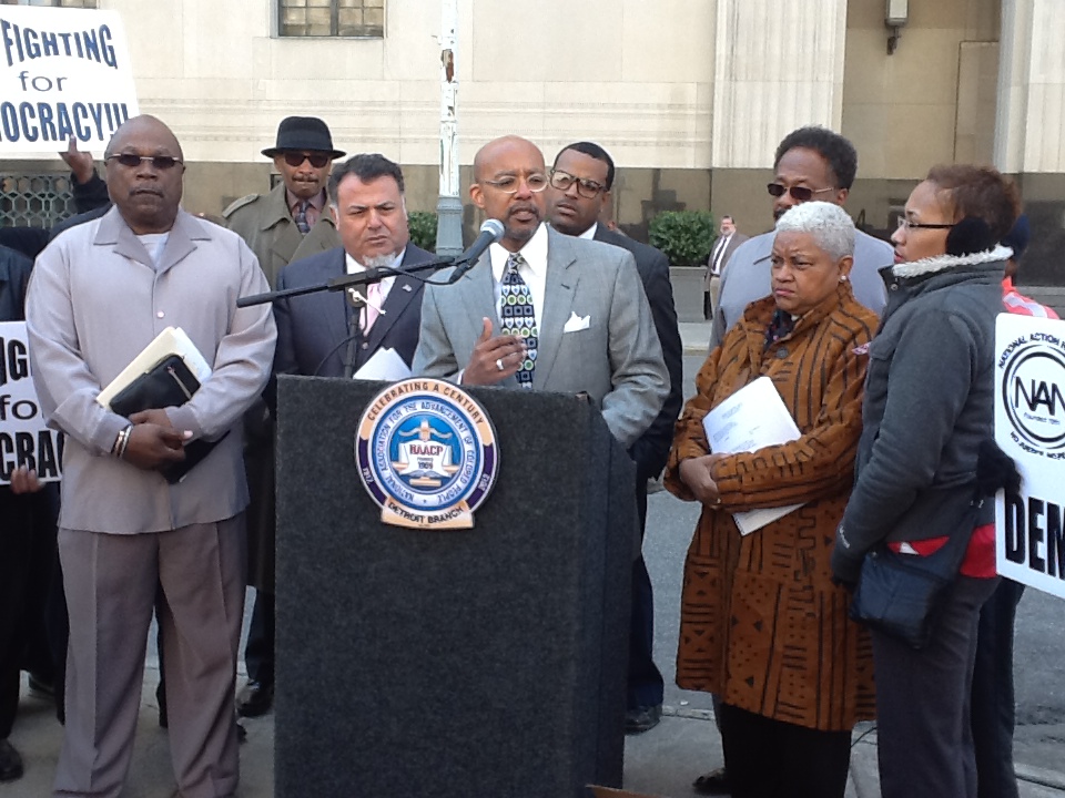 Attorneys Nabih Ayad and Melvin Hollowell (at podium) with plaintiffs announce lawsuit against PA 436 May 13, 2013.