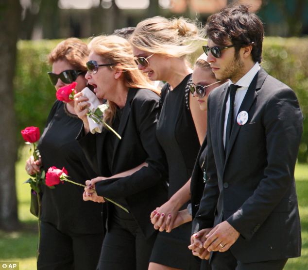 Teen's mother Jacqueline Llach, with flower to face, sobs at funeral.