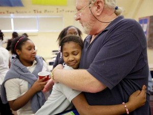 Student hugs teacher at Hutchins as second waits her turn.