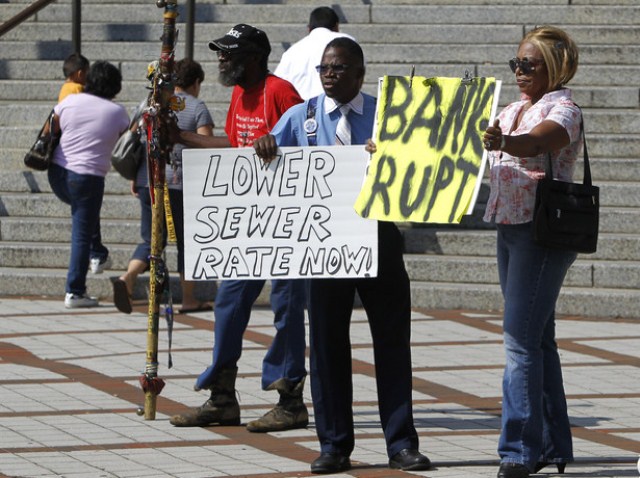 Protesters in Birmingham, Ala. denounce increase in sewage rates that was part of Mongtomery County's exit from bankruptcy. JPMorgan Chase, guilty of massive bond fraud, was also forced to cut its debt payments from the County by 75 percent.