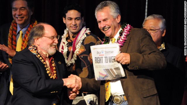 Hawaiian Gov. Neil Abercrombie, left, and former Sen. Avery Chumley hold up a copy of the Star Advertiser after Abercrombie signed a bill legalizing same-sex marriage in Hawaii on Wednesday, November 13, in Honolulu. Hawaii's same-sex marriage debate began in 1990 when two women applied for a marriage license, leading to a court battle and a 1993 state Supreme Court decision that said their rights to equal protection were violated by not letting them marry. Now the state is positioning itself for an increase in tourism as visitors arrive to take advantage of the new law, which took effect December 2.
