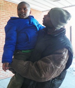 Arthur Simmons, Jr. holds child during DHS visit, after the little boy ran outside crying, "DADDY, DADDY!"
