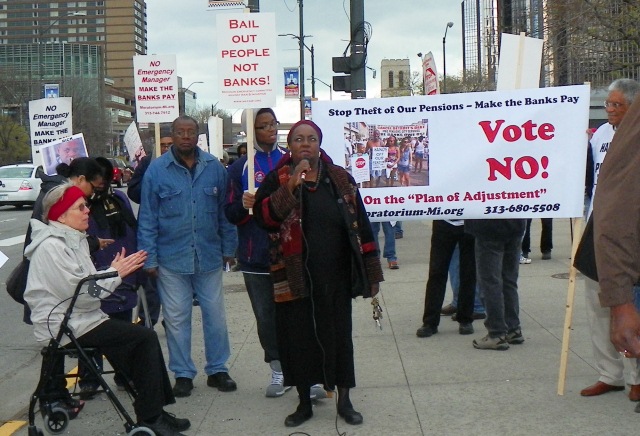 Councilwoman Emeritus JoAnn Watson speaks at May Day rally  with "VOTE NO" on Plan of Adjustment banner behind her.