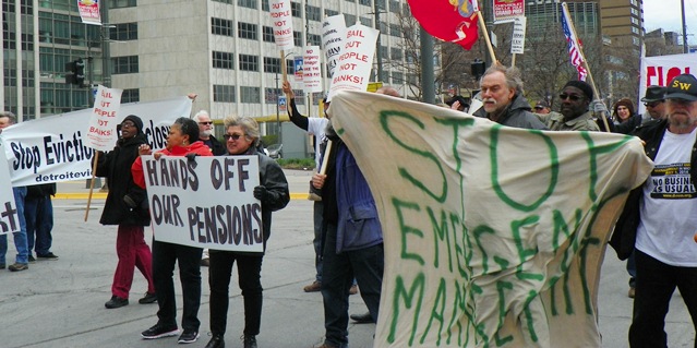 Protesters begin civil disobedience in downtown Detroit, blockading Jefferson Avenue.