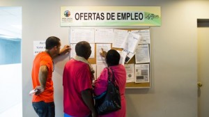 Unemployed Puerto Rican workers check job board.