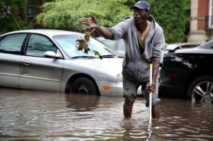 Larry Young of Highland Park tries to clean out his storm drain during Detroit flood, coming up with handful of contaminated sewage. Photo:DFP