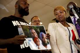 Lesley McSpadden, center, and Michael Brown Sr., left, the parents of Michael Brown, listen as attorney Benjamin Crump speaks during a news conference Monday, Aug. 11, 2014, in Jennings, Mo. Michael Brown, 18, was shot and killed in a confrontation with police in the St. Louis suburb of Ferguson, Mo, on Saturday, Aug. 9, 2014. (AP Photo/Jeff Roberson) 