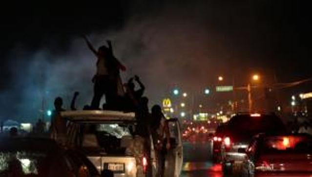 Police, protesters clash for a sixth night in Ferguson, MO Aug. 15, 2014, angry at attempts to criminalize Michael Brown.