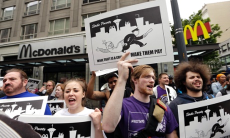 In this Aug. 1, 2013 photo, demonstrators protesting what they say are low wages and improper treatment for fast-food workers stand near a McDonald's restaurant in downtown Seattle. 
