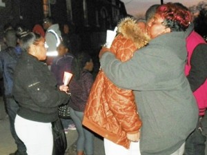 Woman comforts grieving youth during the vigil.