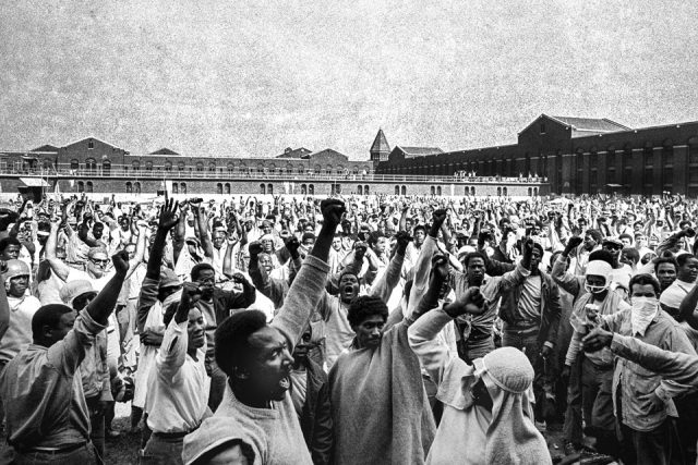 This Sept. 10, 1971 file photo shows inmates of Attica State Prison as they raise their hands in clenched fist salutes to voice their demands during a negotiating session with New York's prison Commissioner Russell Oswald. AP File Photo