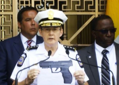 Columbus, Ohio police chief Kim Jacobs holds up photo of gun in question, clearly out of proportion to real size.