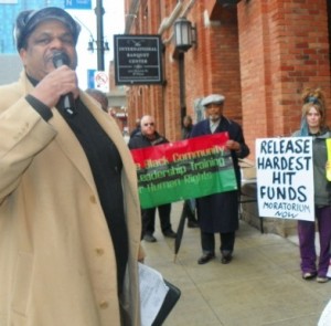 Cornell Squires speaks at rally against tax foreclosures and home auctions. He called all foreclosures illegal because of the lack of yearly property assessments. He was recently working on exposing the fact that all the Wayne County Sheriff's Deeds in these foreclosures have been illegally notarized with a rubber stamp, not a signature, and are invalid.