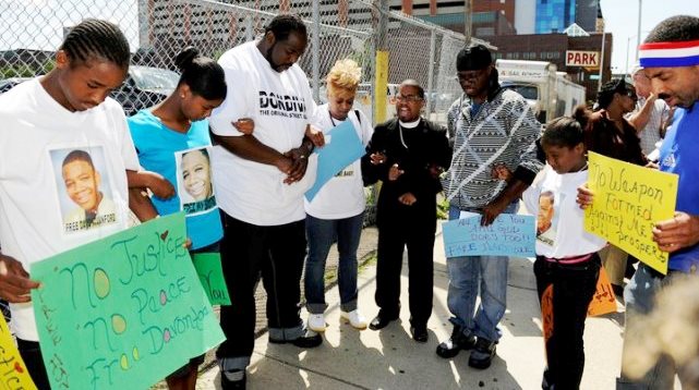 Davontae's mother, Taminko Sanford-Tilmon, with his stepfather and family, pray for his release outside the Frank Murphy Hall, where Kym Worthy's offices are located, in 2012.