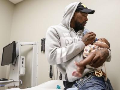 DeMario Stewart of Flint said feeds his son Damonei Stewart during his two month checkup at Hurley Childrens Center. USA Today