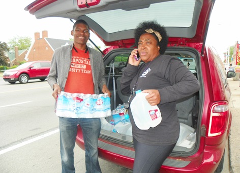 Demeeko Williams and Beulah Walker load water to carry to two Detroit residents, one a senior whose water has been shut off for a year, and another a young woman with a child who has been forced to squat in a Detroit home. Gallons of water are given out freely, with no questions asked.