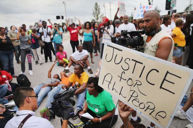 Demonstrators in Ferguson, MO, site of police execution of Michael Brown,