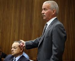 Defense attorney Steve Fishman repeatedly mocked Ms. Jones' allegation that Weekley put his gun to Aiyana's head, as he demonstrates here with Weekley. Wayne Co. ME Carl Schmidt's testimony, however, left that possibility open,