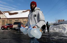 Flint resident carries jugs to obtain clean water. Former Detroit City Councilwoman Sheila Cockrel told Detroiters whose water had been shut off due to inability to pay to go to the Detroit River and get their water there.