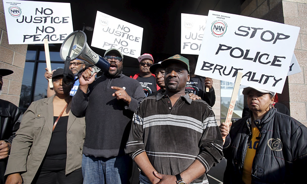 Floyd Dent (center) participates in protest outside the Inkster Police Department. Photo: Reuters/The Guardian