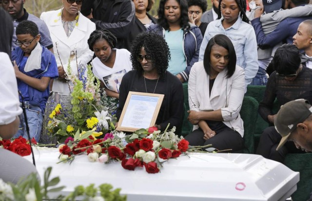 Gloria Darden, mother of Freddie Gray, center, sits in front of Gray's casket at his burial, Monday, April 27, 2015, at Woodlawn Cemetery in Baltimore. Gray died from spinal injuries about a week after he was arrested and transported in a Baltimore Police Department van. (AP Photo/Patrick Semansky)