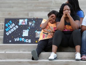 Ikeila Watford, cousin of teenager Andre Green who was shot by IMPD Sunday night, sheds a tear as his aunt Chonda Watford and sister Terika Jackson mourn the loss of his life on Monument Circle during a vigil held Monday evening, August 11, 2015.(Photo: Matt Detrich/The Star)