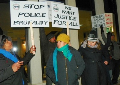 Protesters directly in front of Dearborn Police station block signs of pro-police supporters.