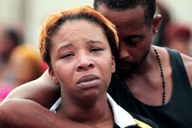 Mike Brown's mother Lesley McSpadden is comforted by her husband, Louis Head, the day her son was killed.