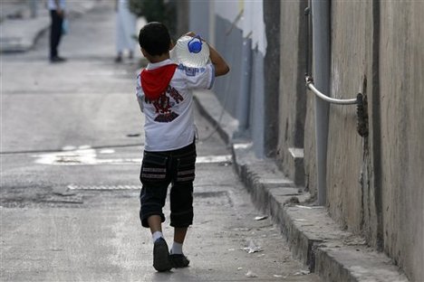 Libyan child carries jug of water after U.S./CIA bombing of his country under the Obama administration destroyed its world-class water infrastructure.