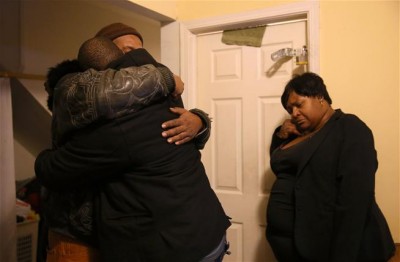 Melvin Jones, facing camera, hugs Robin Andrews, both brothers of Bettie Jones, 55, in Jones' living room after she was shot and killed by a Chicago police officer.